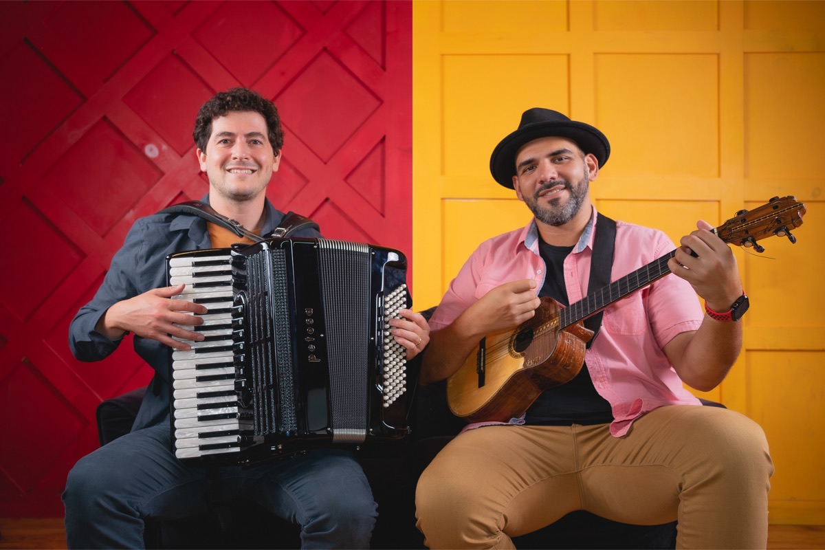 Jorge Glem and Sam Reider in front of a red and yellow wall